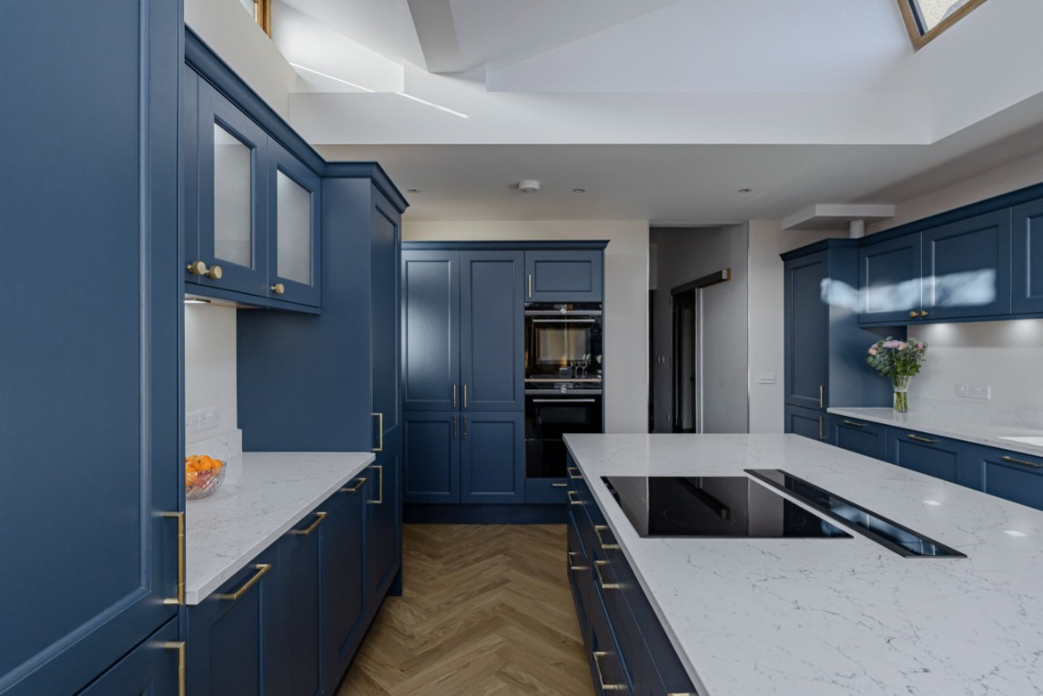 Blue shaker fitted kitchen with white worktops and brass handles by 21 Kitchens in Ayrshire.