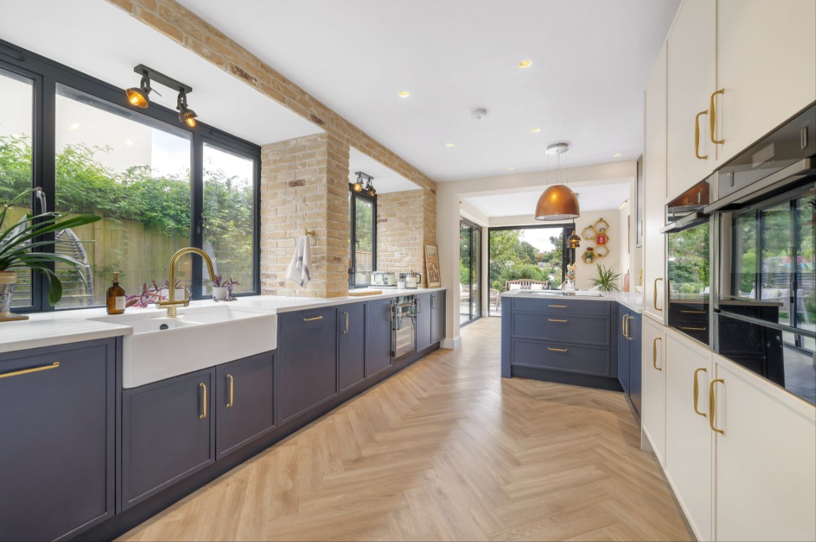 Navy Nobilia kitchen near Stewarton, Ayrshire, featuring a white quartz peninsula, brass handles and a copper extractor hood.